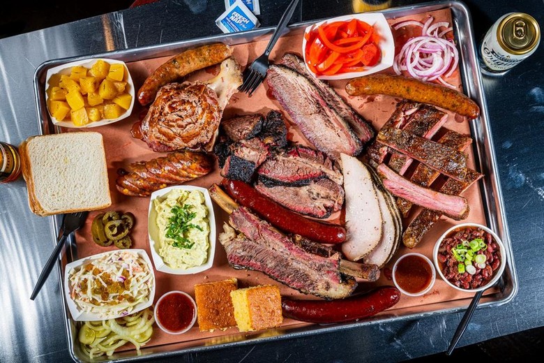 Đĩa BBQ tổng hợp với thịt, salad bắp cải và bánh mì bắp