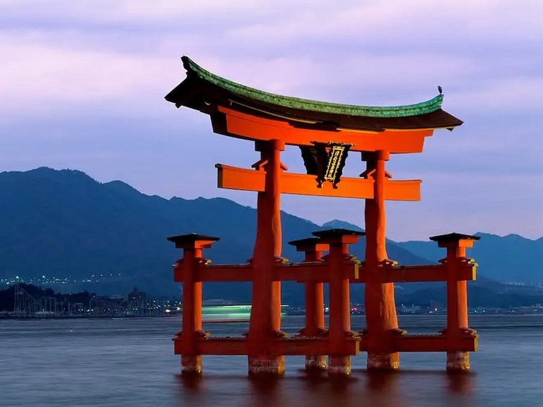 Cổng torii gỗ đỏ trong Vườn Trà Nhật Bản tại Công viên Cổng Vàng, San Francisco, hoa anh đào nở hai bên lối vào