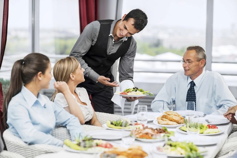  Nhân viên phục vụ mang đồ ăn ra bàn tại nhà hàng Mỹ