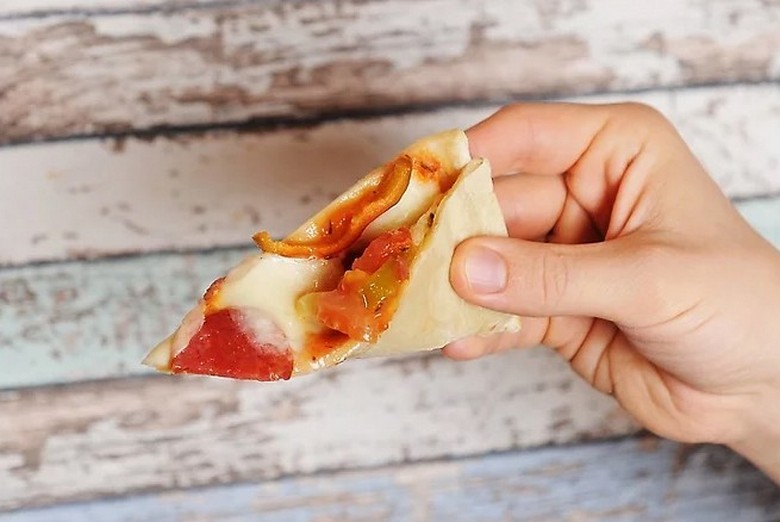 Miếng pizza New York được gập đôi theo chiều dài khi ăn